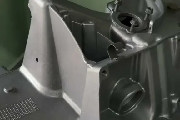 Frisch gereinigtes Aluminiumgehäuse in der Strahlkabine, die Kabinenwand dahinter